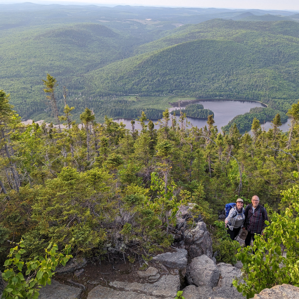 Deux agents de terrain dans l'habitat de la grive de Bicknell, avec les montagnes en arrière-plan.