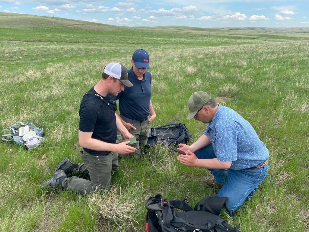 Two staff deploying recorders with a rancher in Saskatchewan