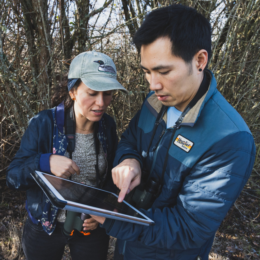 Two staff members consult NatureCounts on the mobile application.
