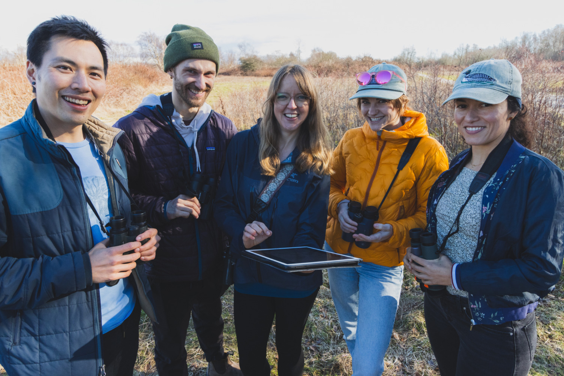 Five staff smile as they pose together in the field.