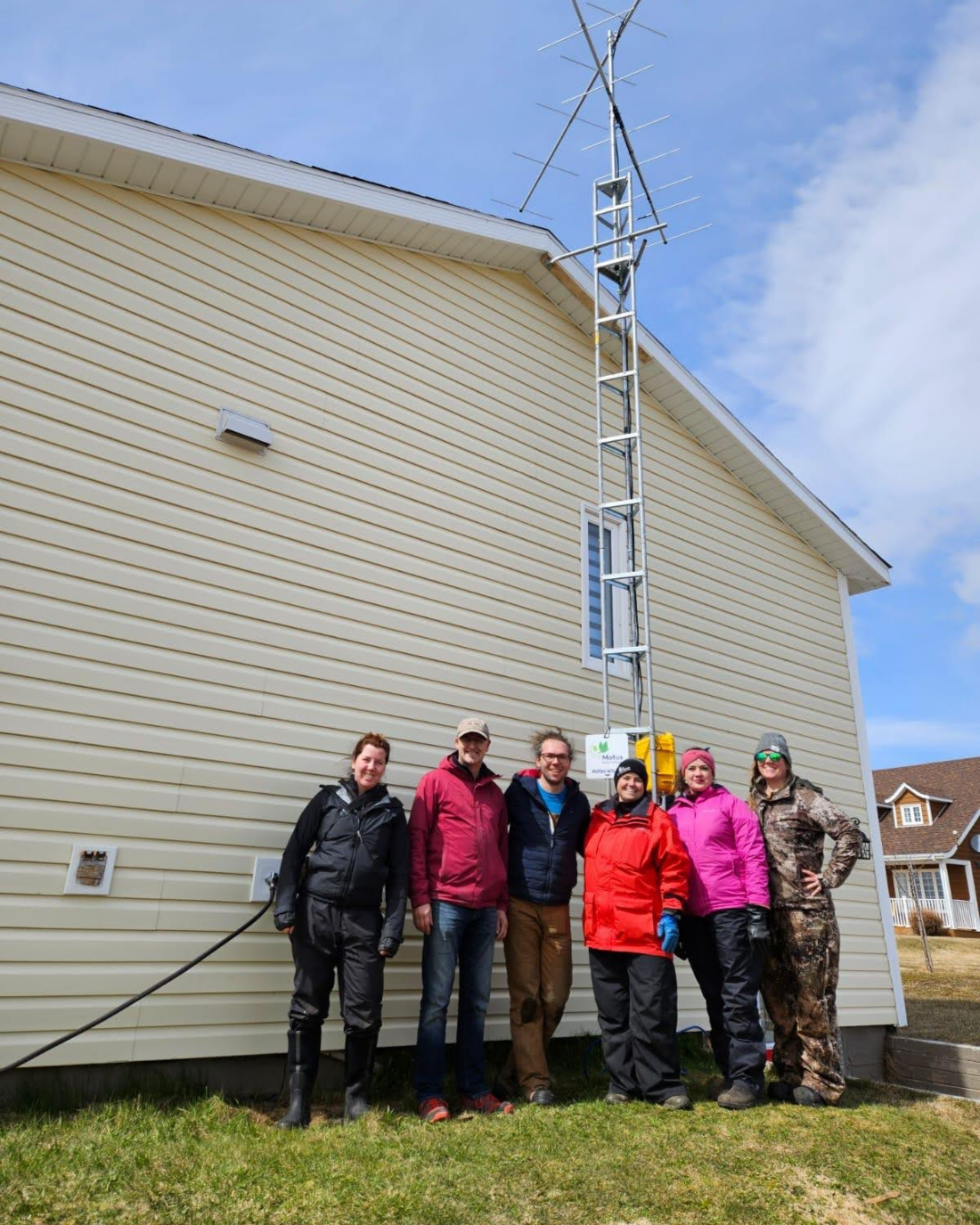 Erica Geldart, coordinatrice du programme Motus chez Oiseaux Canada, Vernon Buckle, photographe animalier et citoyen-chercheur, Lucas Berrigan, coordinateur du programme Motus chez Oiseaux Canada, Sara Pearce-Meijerink, biologiste de la faune au Conseil communautaire de NunatuKavut, Kayla Brown, technicienne en gestion de la faune au Conseil communautaire de NunatuKavut, et Regina Wells, biologiste de la faune à Environnement et Changements climatiques Canada, à côté de la station Motus d’English Point, à Terre-Neuve-et-Labrador.